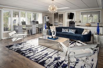 a living room with a blue couch and white chairs at Waterview at Rocky Point, Tampa, FL